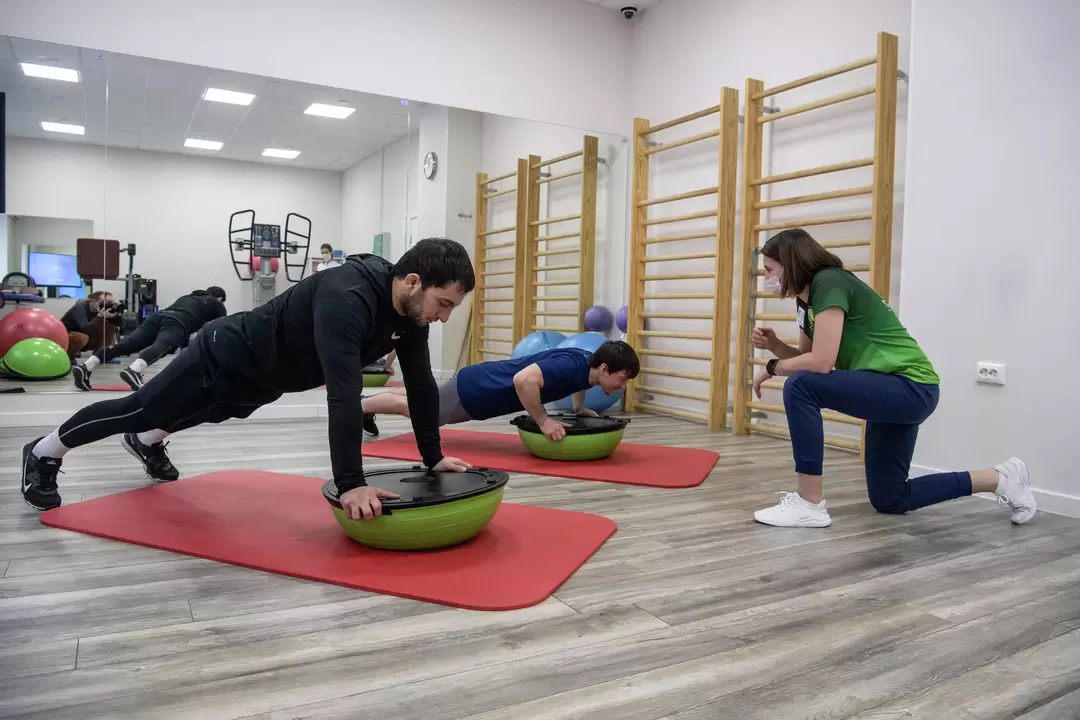 Rehabilitation therapist conducts exercise therapy courses with patients suffering from back pain